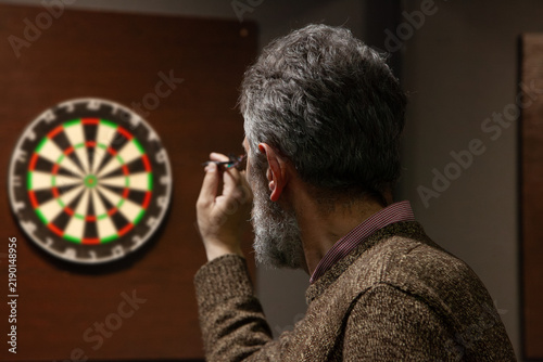Bearded man playing darts