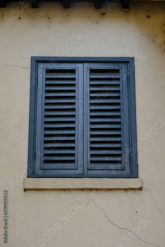 A window with old wooden shutters fully closed, Italy, Verona