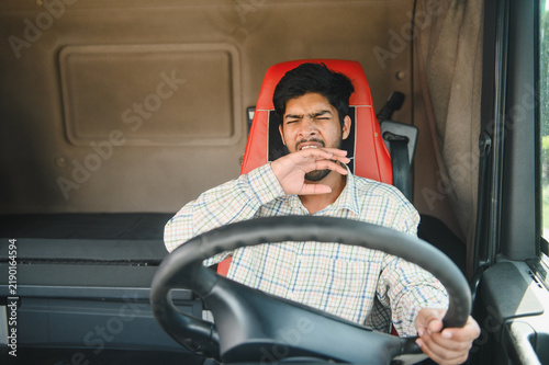 Foto Indian truck driver yawning while driving truck