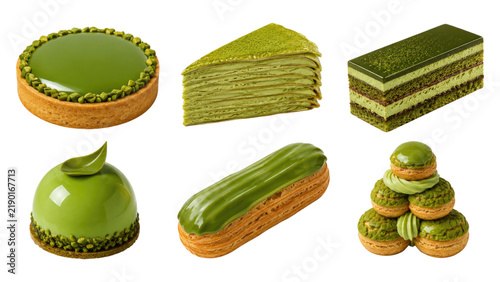 Assortment of glossy green matcha pastries including tart, crepe cake slice, layered cake, mousse dome, éclair, and macaron tower