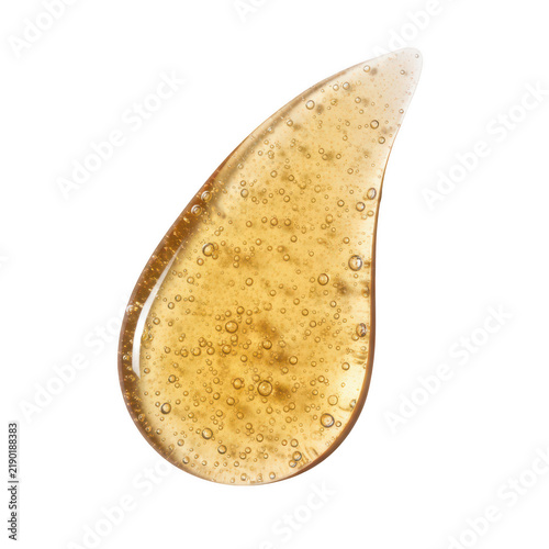 A single drop of golden yellow cosmetic gel with exfoliating scrub particles for skincare beauty product ad