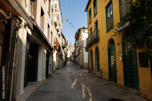 Foto Narrow Cobblestone Street with Historic Buildings and Distant Be