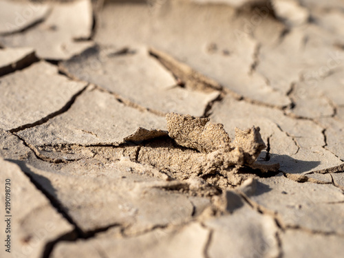 Fotografie Close-up of broken and peeling dry soil during extreme drought, showing cracked parched earth, severe moisture loss and land degradation caused by prolonged water scarcity