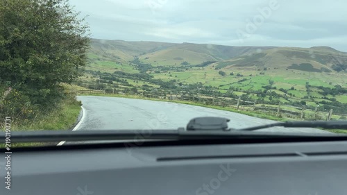 Car dashboard view driving down the hill, downhill in Peak District National Park, England.
