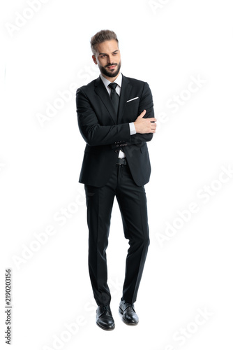 Принти на полотні Elegant man in black suit standing with crossed arms