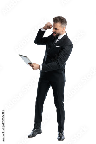 Картината върху платно Enraged formal man holding tablet and raising fist