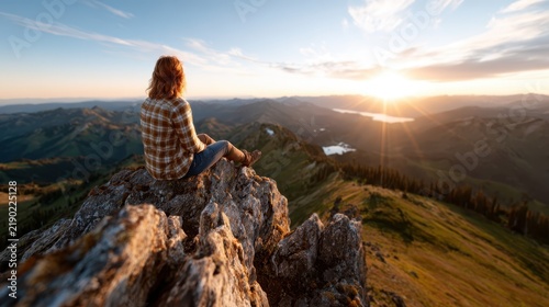 A serene scene of a person sitting on a rocky outcrop, gazing at the breathtaking mountain view during sunset, evoking feelings of solitude, reflection, and connection with nature.
