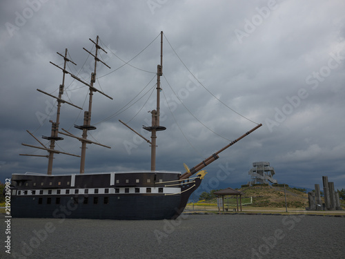 A replica sailing galleon monument on the grass by the coast, Japan