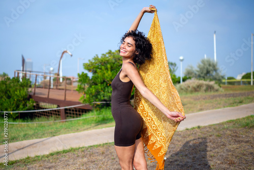 фотографія Woman smiling holding sarong feeling freedom outdoors