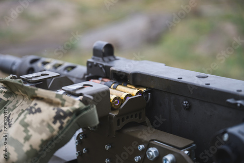 Canvastavla Close up view of a heavy machine gun with brass ammunition cartridges loaded into the feeding mechanism