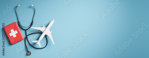 Travel health insurance concept with airplane, medical kit, and stethoscope on blue background with clean copy space for banner design. 3D Rendering