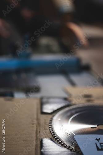 Obraz na plátne Tools and materials arranged on a work table, showcasing a circular saw blade wi
