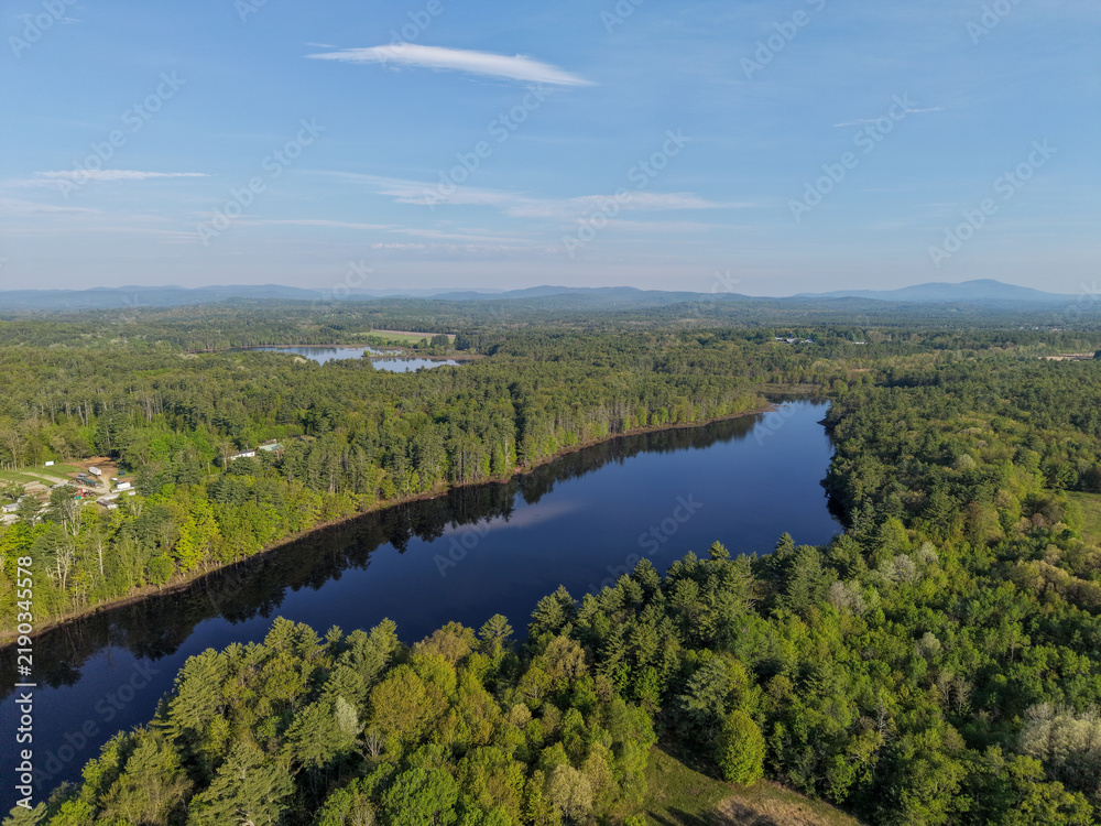 Obraz premium Aerial View of Stumpfield flowage in Hopkinton, NH Through Dense Forest and Lakes Under a Clear Blue Sky