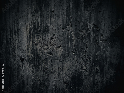 Dark grunge concrete wall background featuring rough weathered texture and moody shadows