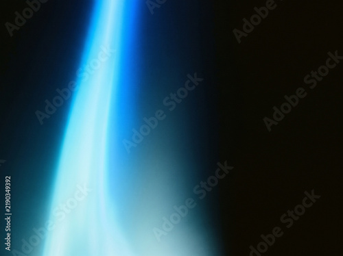 Vibrant blue light beam shining vertically in dark background creating dramatic contrast