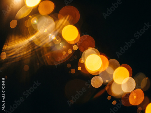 Luminous gold bokeh lights glowing with soft blur against dark background