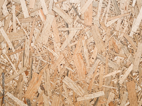 Textured OSB board background featuring compressed wooden flakes in natural beige tones