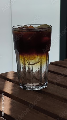 Iced espresso tonic coffee mixing on a wooden table