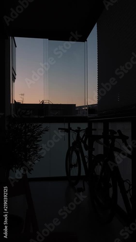 Silhouette of bicycles on an apartment balcony at sunset