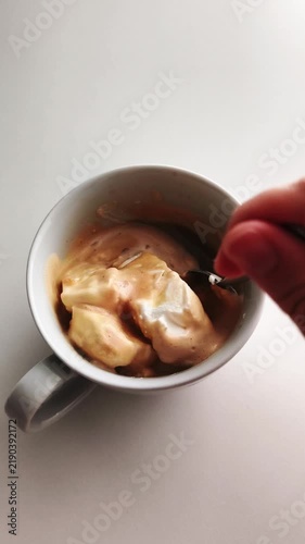 Hand stirring creamy affogato coffee dessert