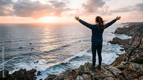 Joyful Woman Standing on Rocks at Sunset Overlooking Ocean