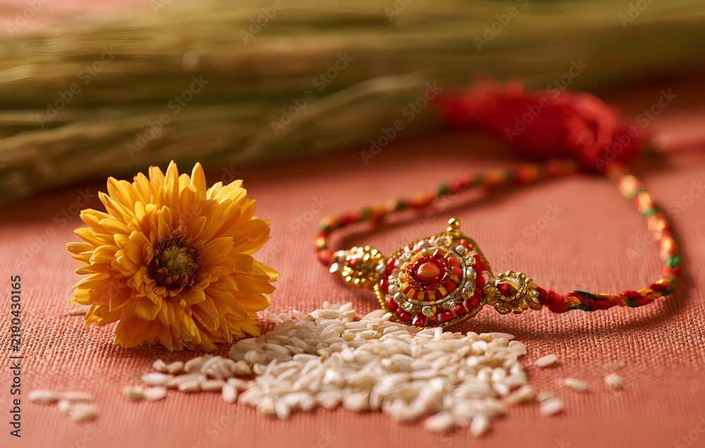 Obraz premium Raksha Bandhan, an Indian celebration marked by the beautiful Rakhi, rice grains, and flowers, is a traditional wrist band in India. It represents the love shared between sisters and brothers