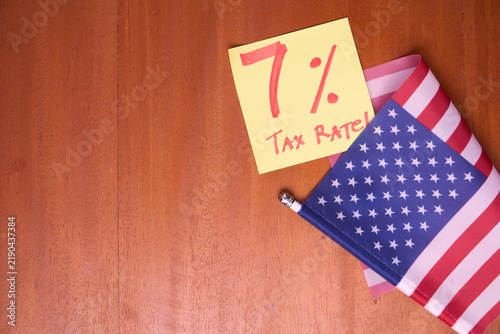 7 percent tax rate note with US flag on wooden table for American effective import tariff policy 2026 concept