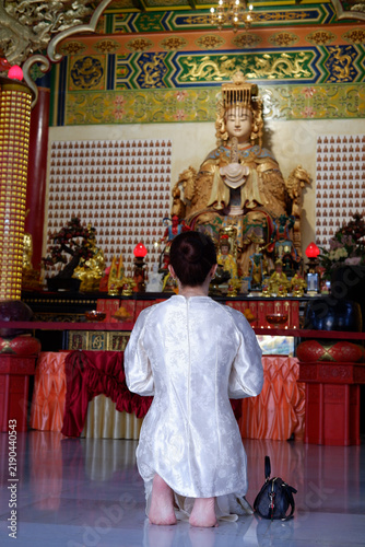Fotografie Spiritual atmosphere: worshippers paying respects in a Buddhist temple in Malaysia