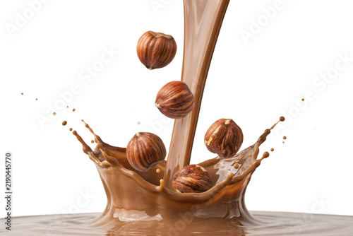 Whole hazelnuts falling into a splash of liquid milk chocolate stream isolated on a transparent background