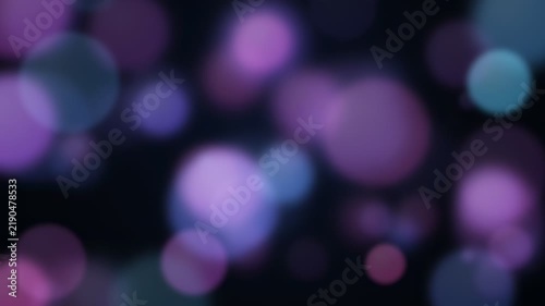 Abstract purple and blue bokeh light particles floating on a dark background