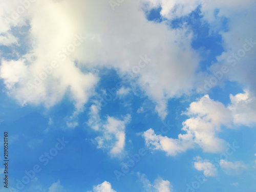 Foto Wispy white clouds drift across light blue sky creating soft and serene natural backdrop perfect for peaceful design