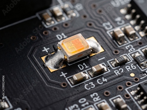 Foto Amber color surface mount light emitting diode soldered on black printed circuit board