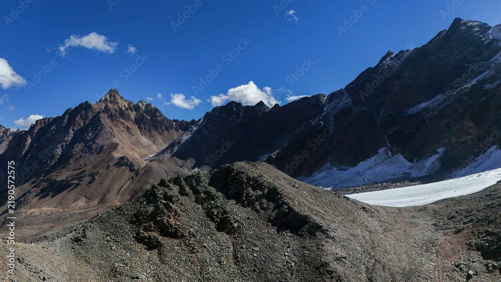 Obraz premium Aerial Drone View of Pin Bhaba Pass Summit in Himachal Pradesh with Snow Covered Glaciers, Rugged Rocky Mountains and Dramatic High Altitude Himalayan Landscape