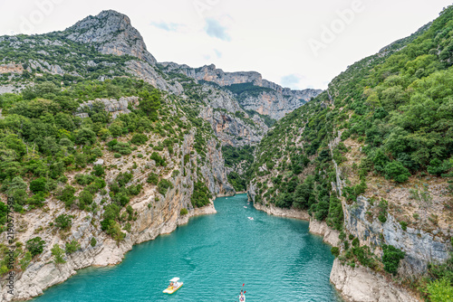 Tourists enjoying turquoise waters of the Verdon River in France, paddling pedal boats and kayaks on a sunny day