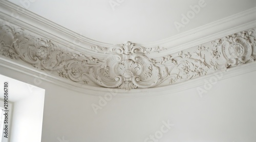 Ornate white plaster ceiling molding featuring intricate floral rococo style carvings