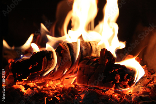 Burning wood with a bright fire in the fireplace