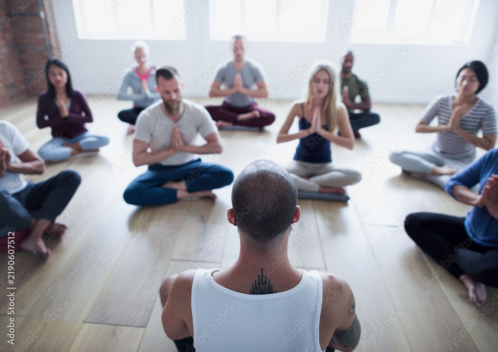 Fototapeta premium Diverse group of people in a yoga class doing a meditating pose