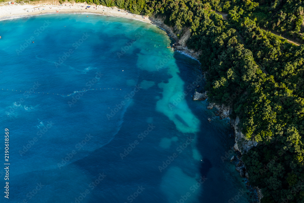 Naklejka premium Kakome Beach aerial view of a secluded coastal cove with turquoise water, sandy beach, forest and rocky shoreline
