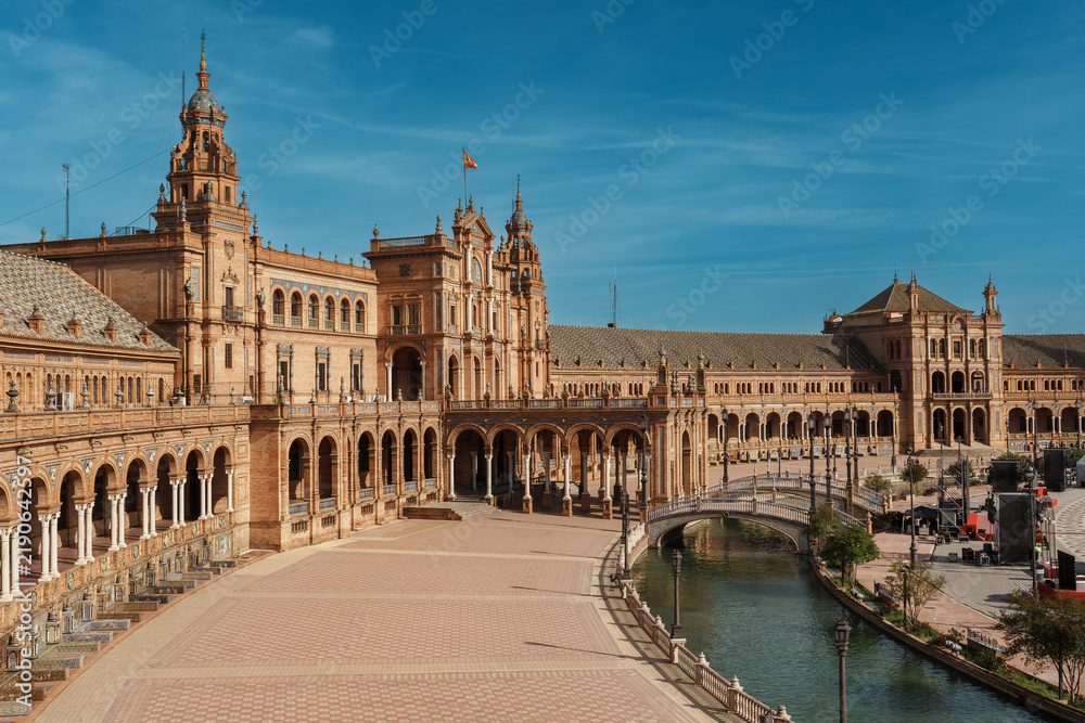 Obraz premium Panoramic view of Plaza de Espana with canal, bridge, and tower in Seville