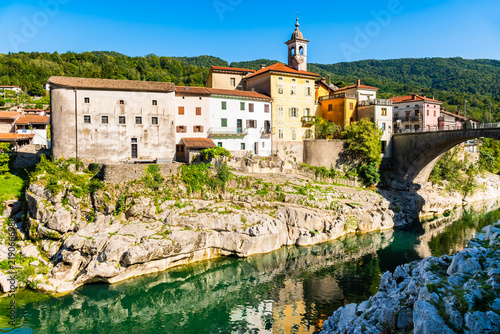 Obraz na płótnie Colorful historic houses and a stone bridge along the emerald Soca River in the
