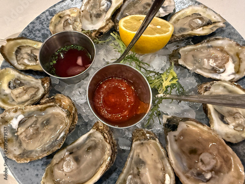 Plate with fresh open oysters on ice