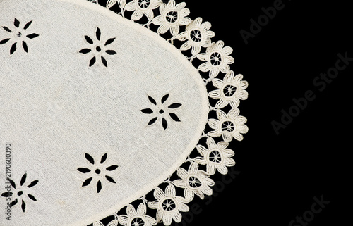 Oval crochet napkin doily lace, antique crocheted Grandma's Doily, detail of bobbin needle lace embroidery, tablecloth, one napkin isolated on black background. Craft vintage linen. Flat lay, border