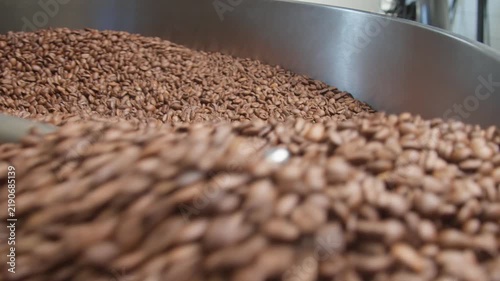 Freshly roasted coffee beans cooling in roaster tray, closeup