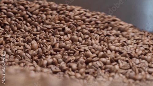 Freshly roasted coffee beans cooling in roaster tray, closeup
