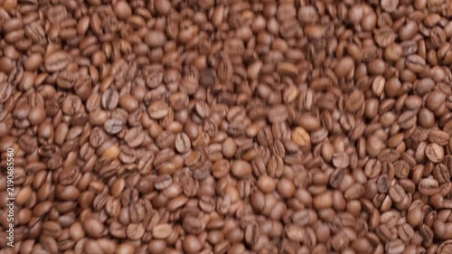 Freshly roasted coffee beans cooling in roaster tray, closeup