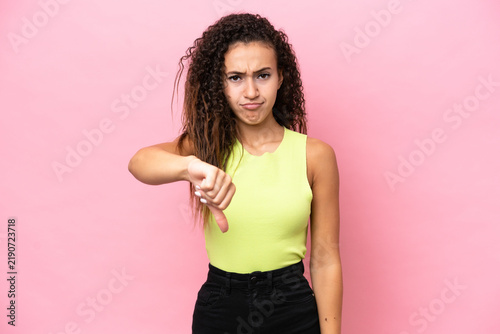 Fototapeta kuchenna Young hispanic woman isolated on pink background showing thumb down with negative expression