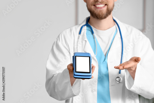 Male doctor with payment terminal in clinic