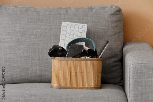 Quadro su tela Box with different devices on sofa at home, closeup