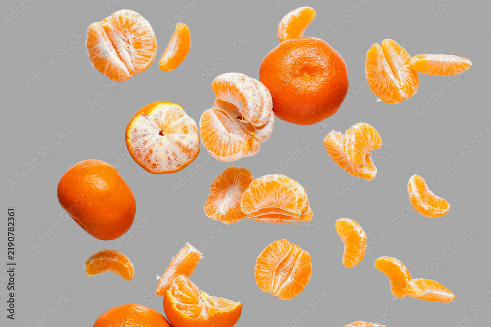 Obraz premium Flying sweet ripe mandarins on grey background