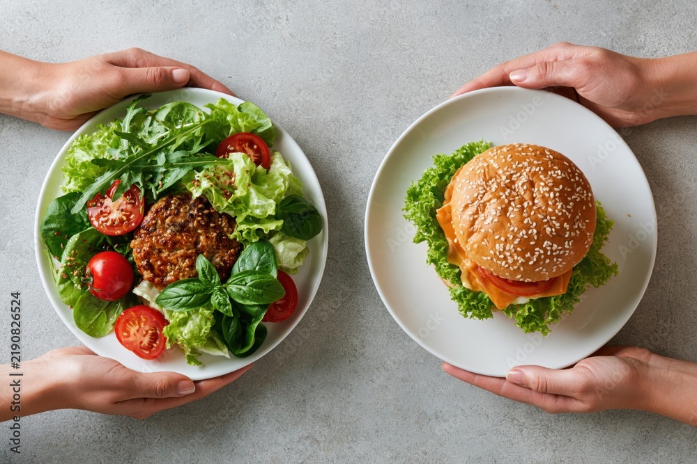 Obraz premium Hands choosing healthy salad versus fast food burger